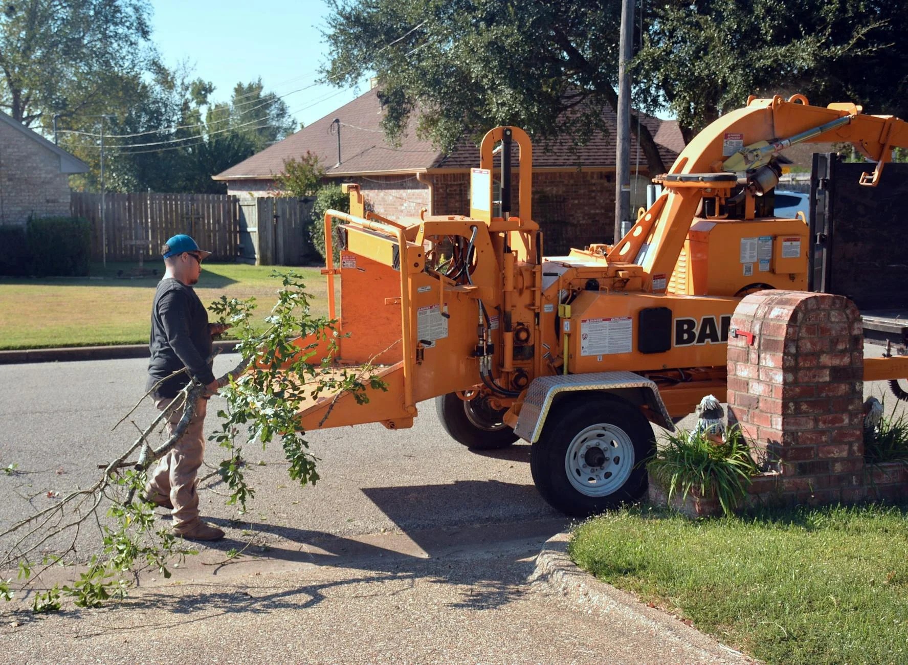 Guy placing branches into woodchipper